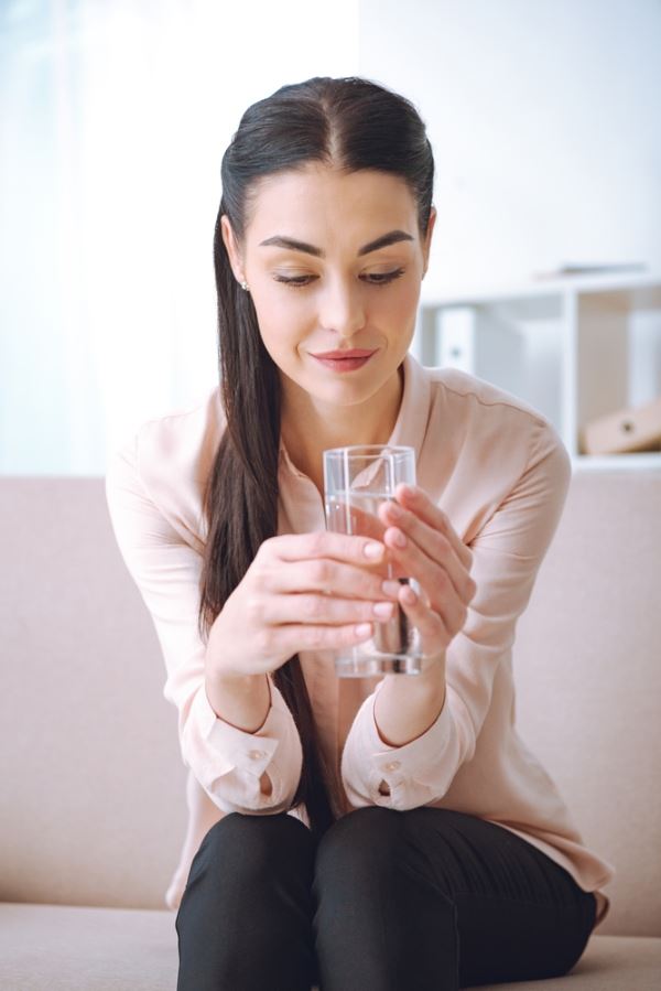 A girl with a glass of water after Zip filter replacement